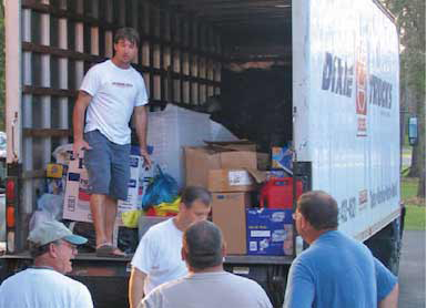 Men distributing food and supplies from a truck